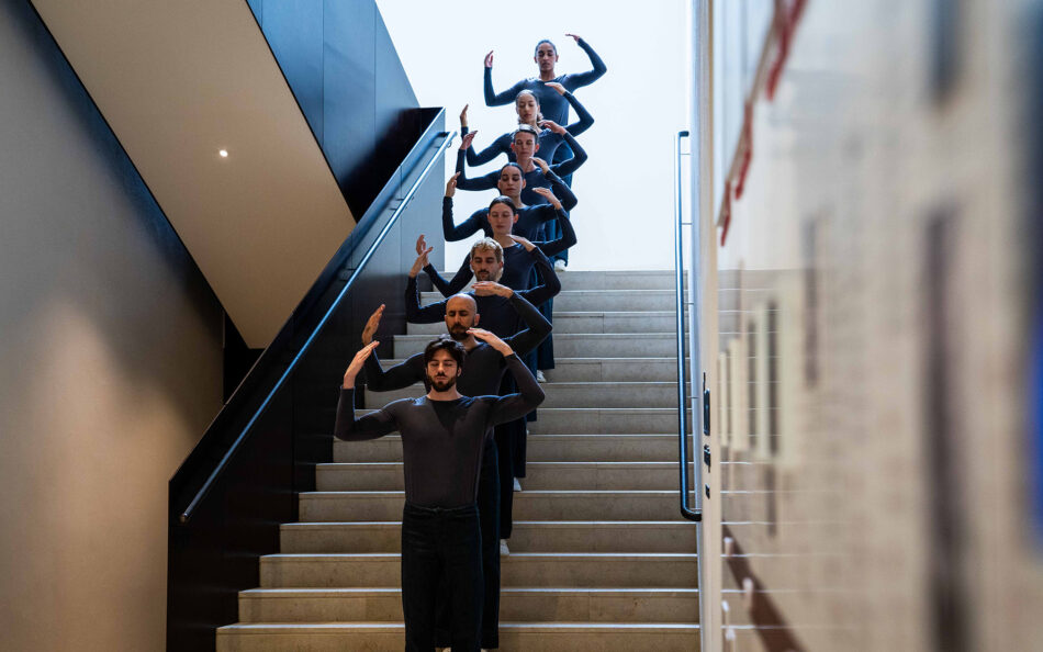 Dancers from Trisha Brown Dance Company descend a staircase in unison, performing site-responsive choreography during The Dark Festival at PS21.