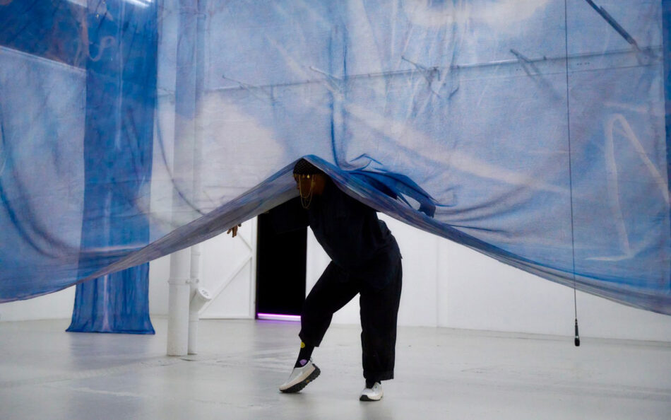 Autumn Knight performing solo within a spatial installation, engaging mirrors and architectural elements during The Dark Festival.